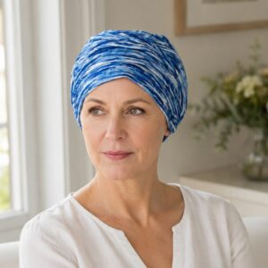 mujer-panuelo-oncologico-azul-atlantico Mujer con pañuelo oncológico azul Atlántico en un interior luminoso
