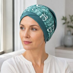 mujer-panuelo-oncologico-bambu-agua-marina Mujer con pañuelo oncológico de bambú Agua Marina junto a una ventana