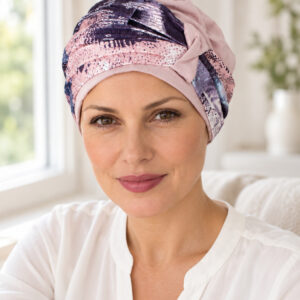 panuelo-dinamarca-lifestyle Mujer con pañuelo Dinamarca rosa y estampado abstracto junto a una ventana